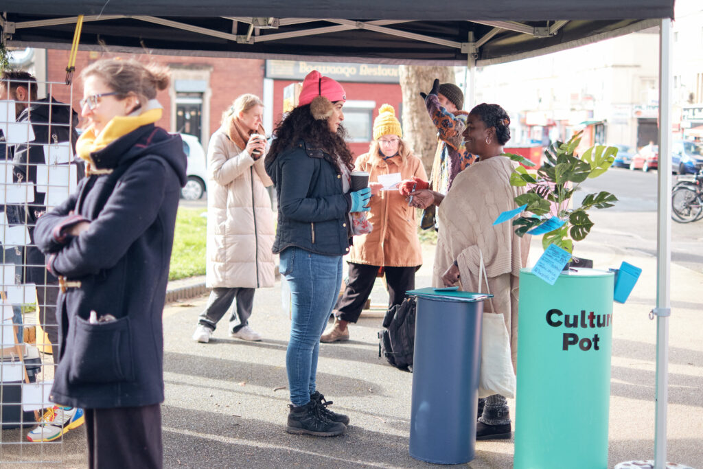 Image of people talking under a gazebo on the street